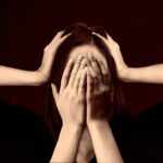 A woman with a thoughtful expression resting her hand near her face